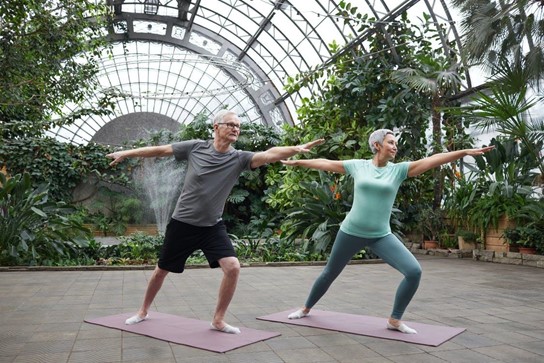 An middle-age couple performing yoga to stay active